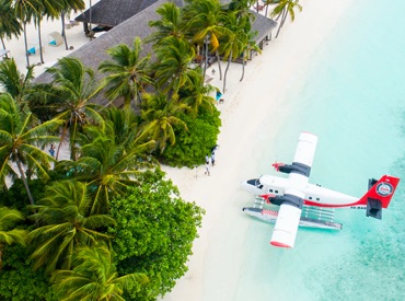 Photo of a seaplane on the beach near a coastal paradise