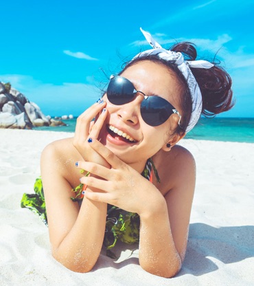 Photo of a woman lying on a beach with a million-dollar smile